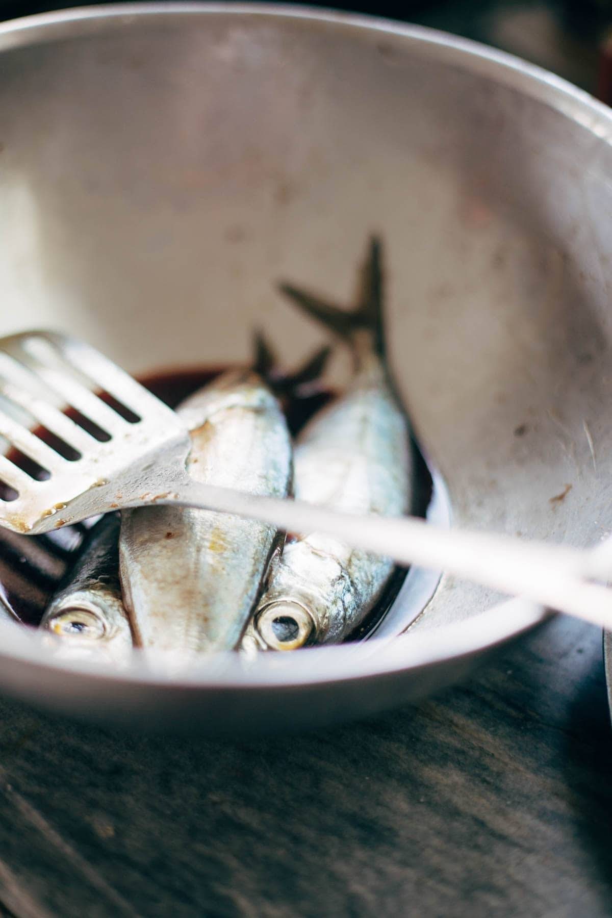 Fish in a bowl with a spatula.