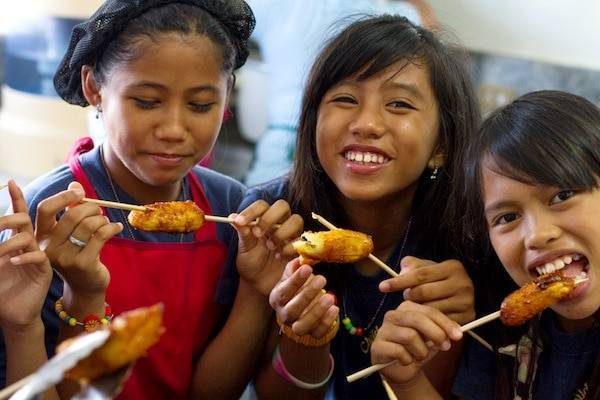 Women eating fried bananas.