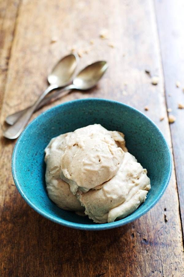 Peanut Butter Banana Ice Cream in a blue bowl with two spoons.