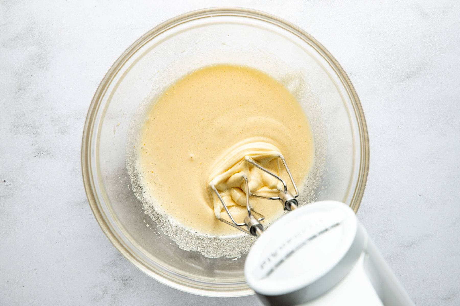 Breating eggs and sugar in a bowl.