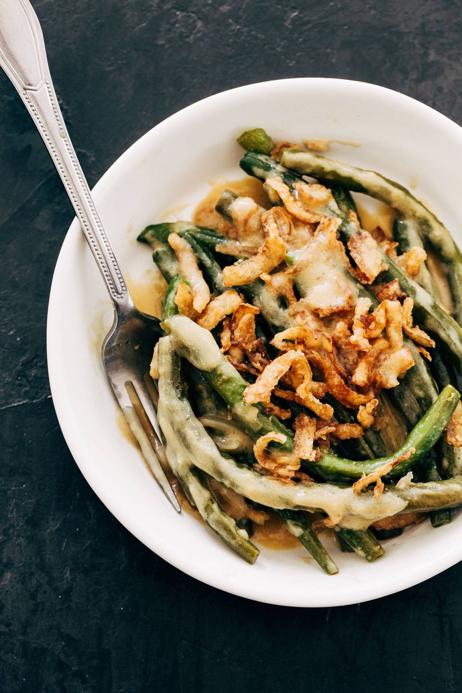 Green bean casserole on a plate with a fork.
