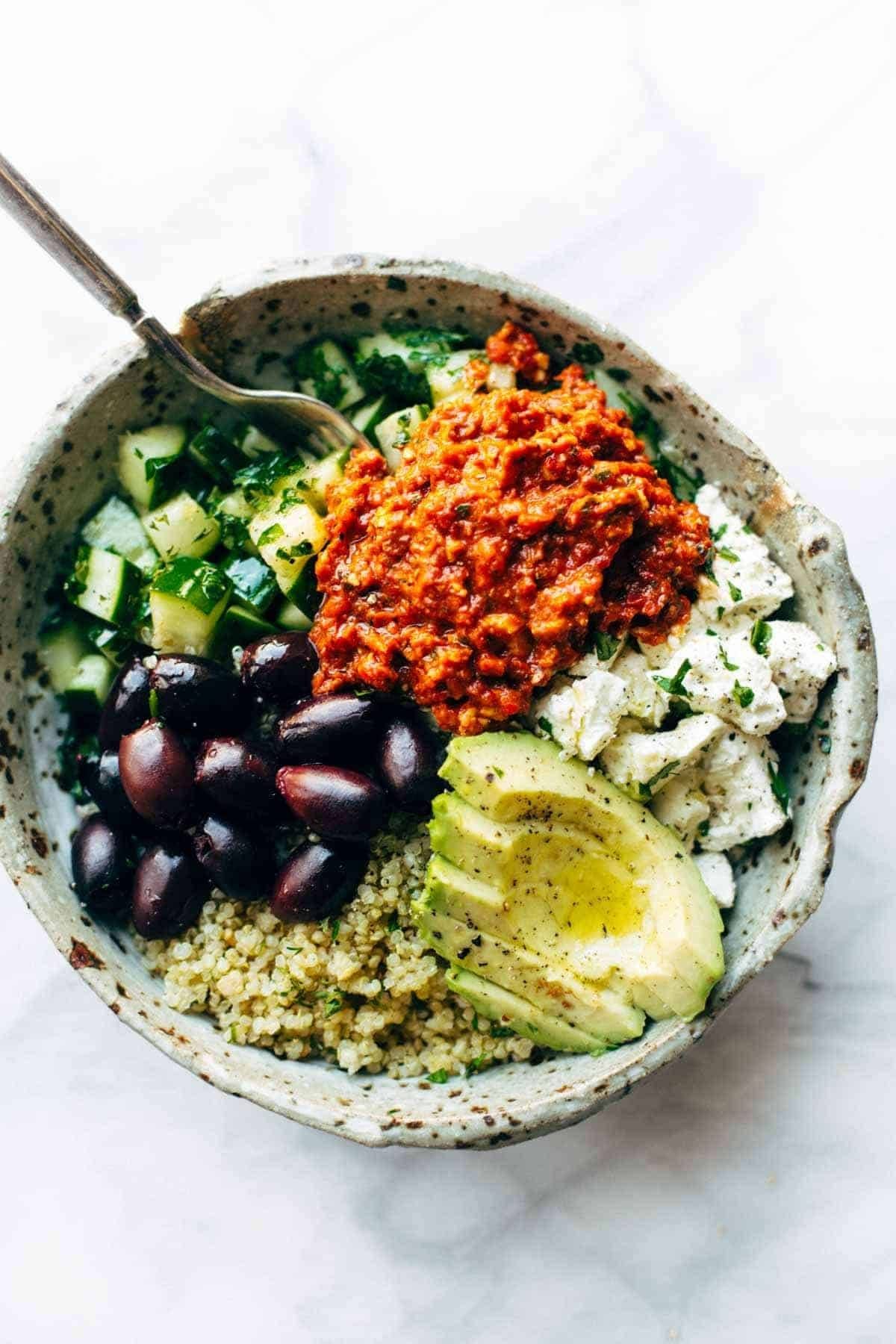 Mediterranean quinoa bowl with red pepper sauce.