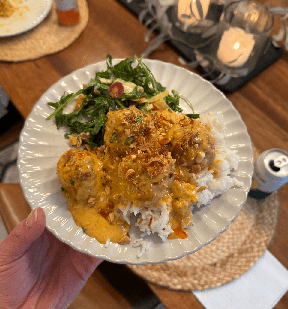 Plate of yellow curry meatballs at a dinner table.