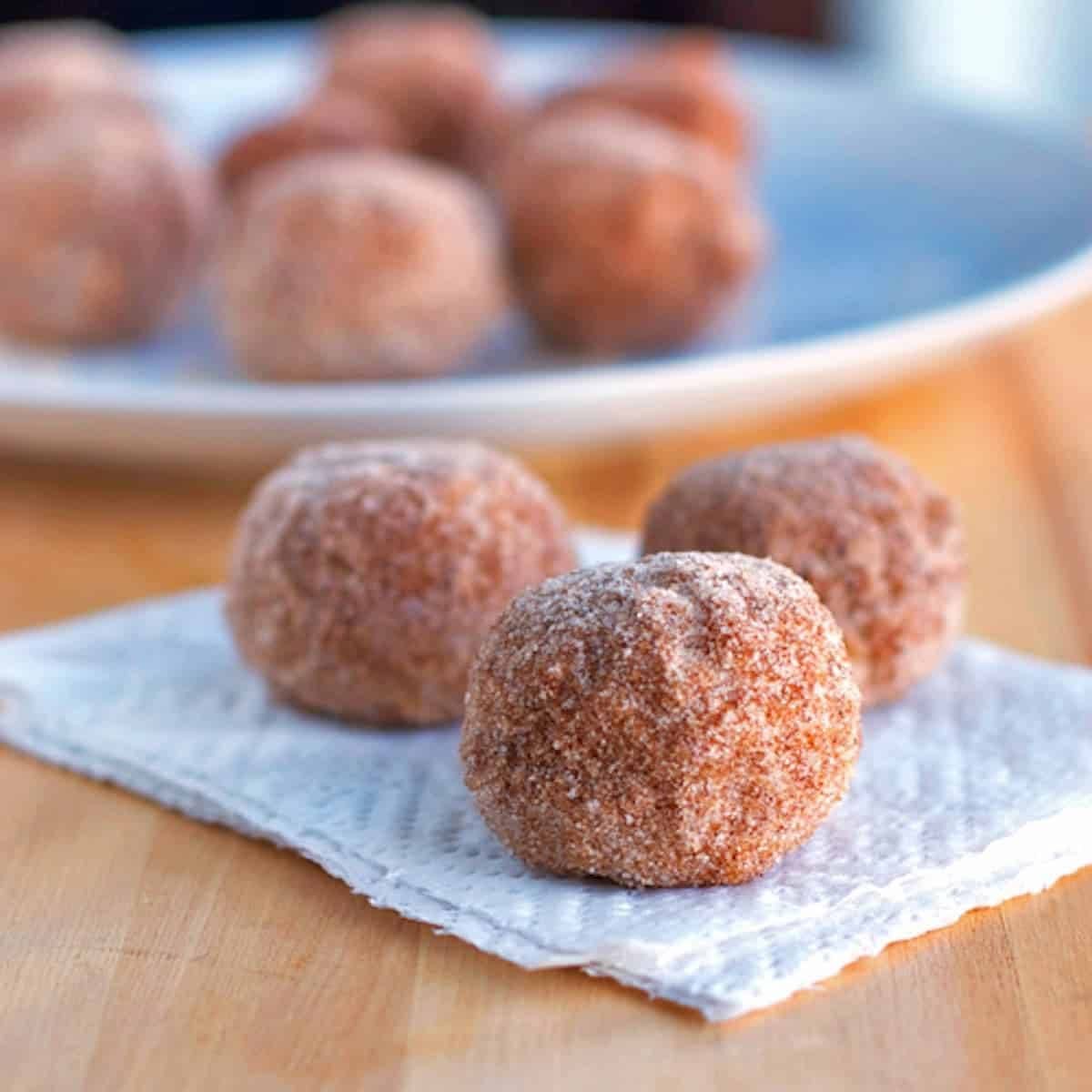Cinnamon sugar donut balls on a napkin.