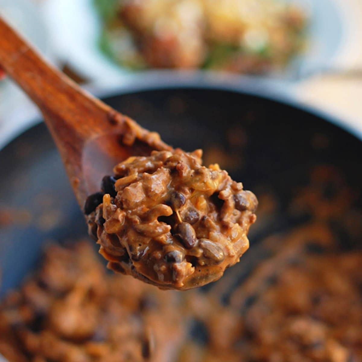 Tex-mex taco salad topped with tex-mex style ground beef on a spoon.