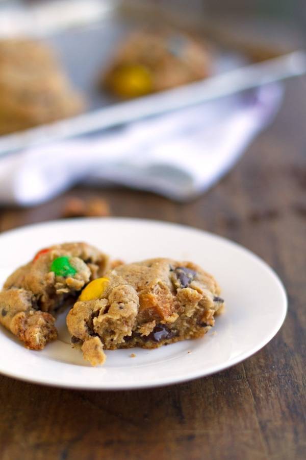 Pieces of butterfinger monster cookies on a white plate.