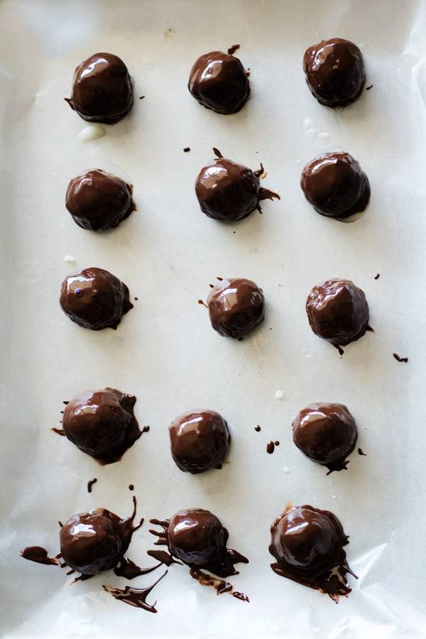 Dark chocolate coconut bites on parchment paper.