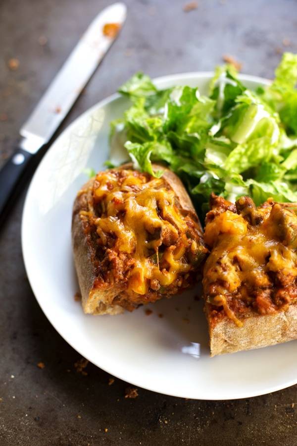 Pizza bread and lettuce on a plate with a knife in the background.