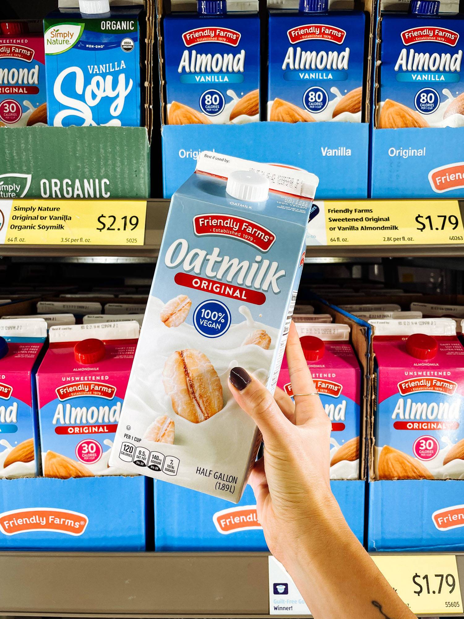 White hand holding oatmilk from ALDI.