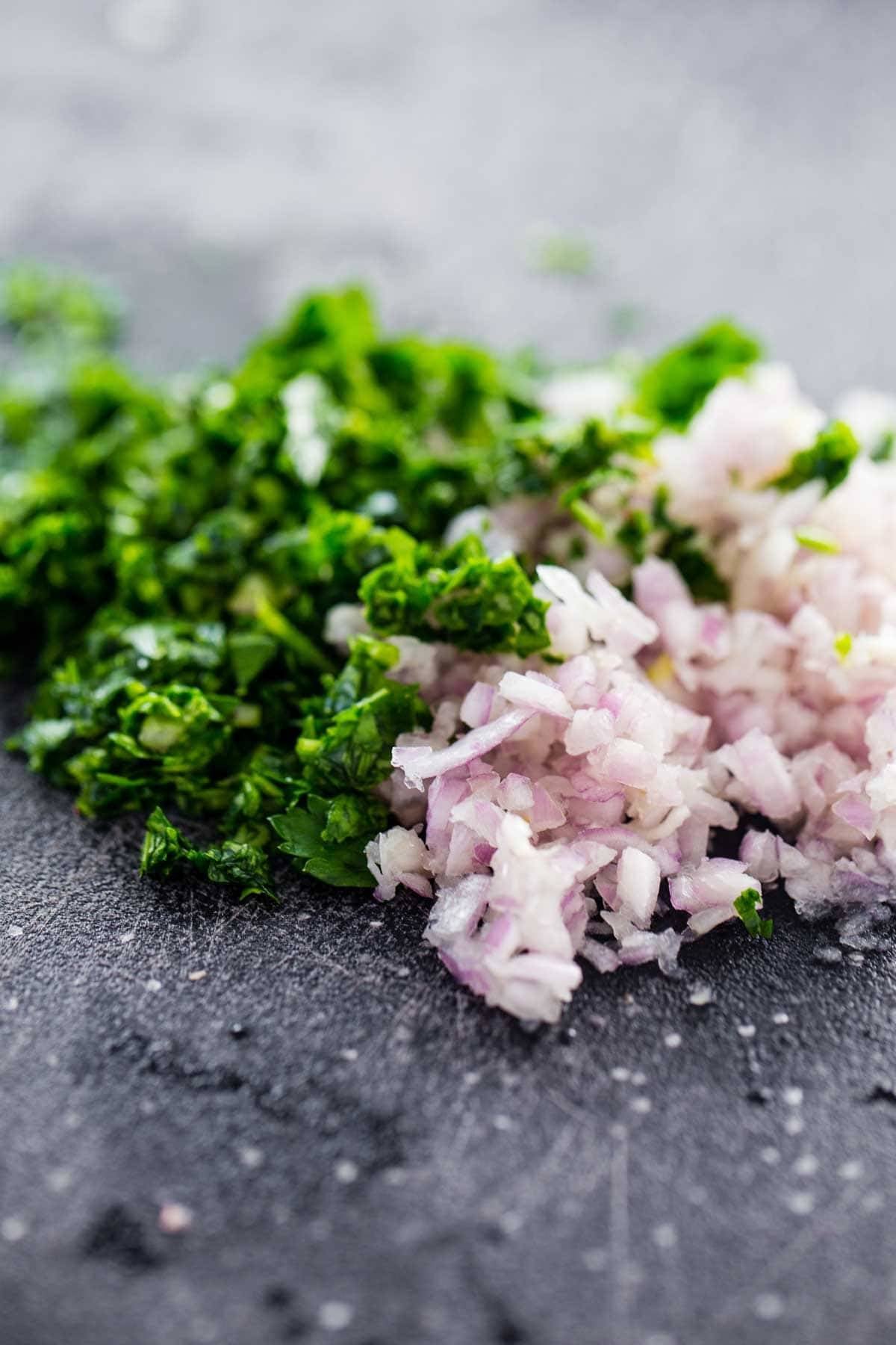 Onions and herbs on a cutting board.