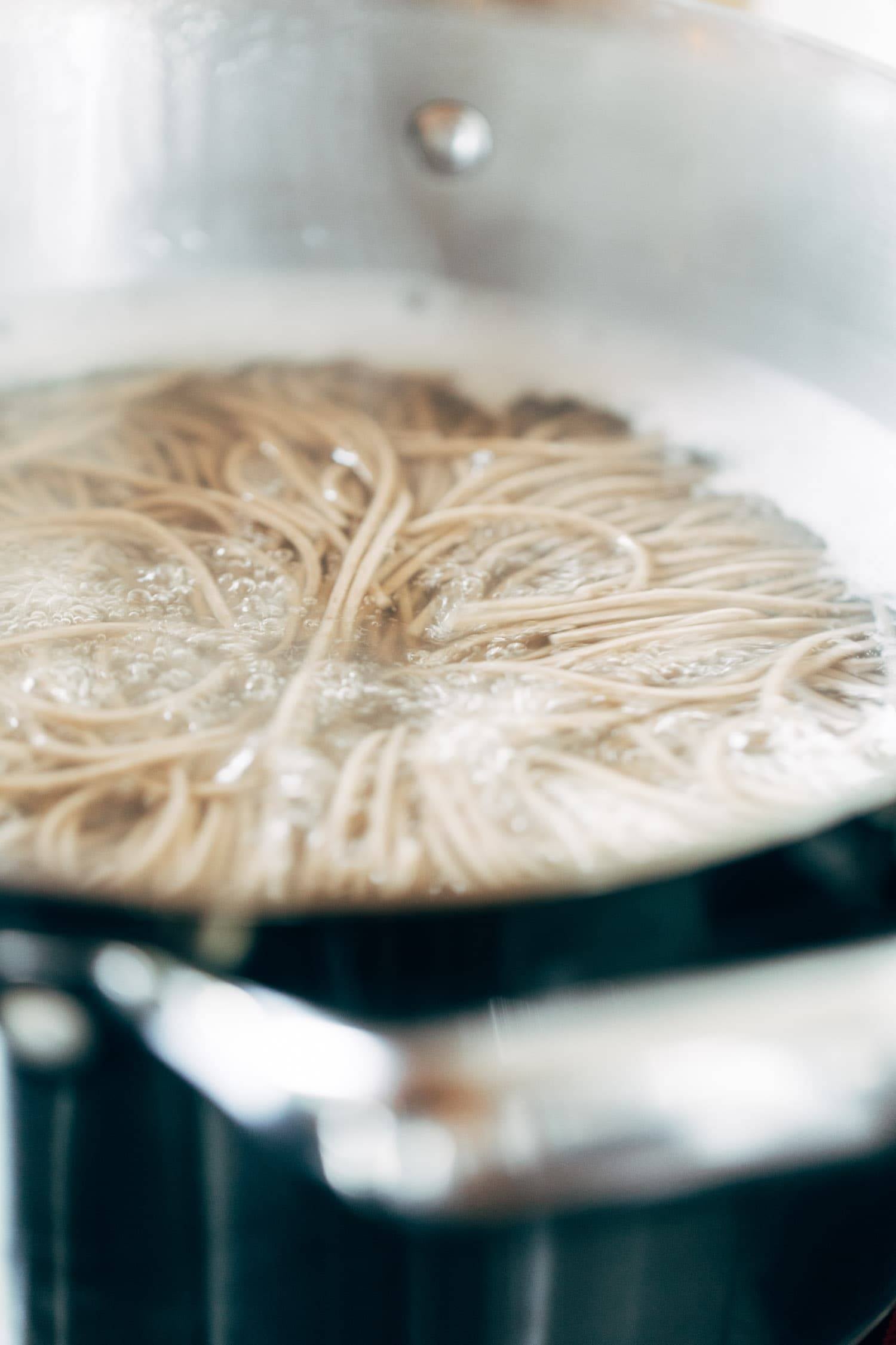 Soba noodles boiling a pot.