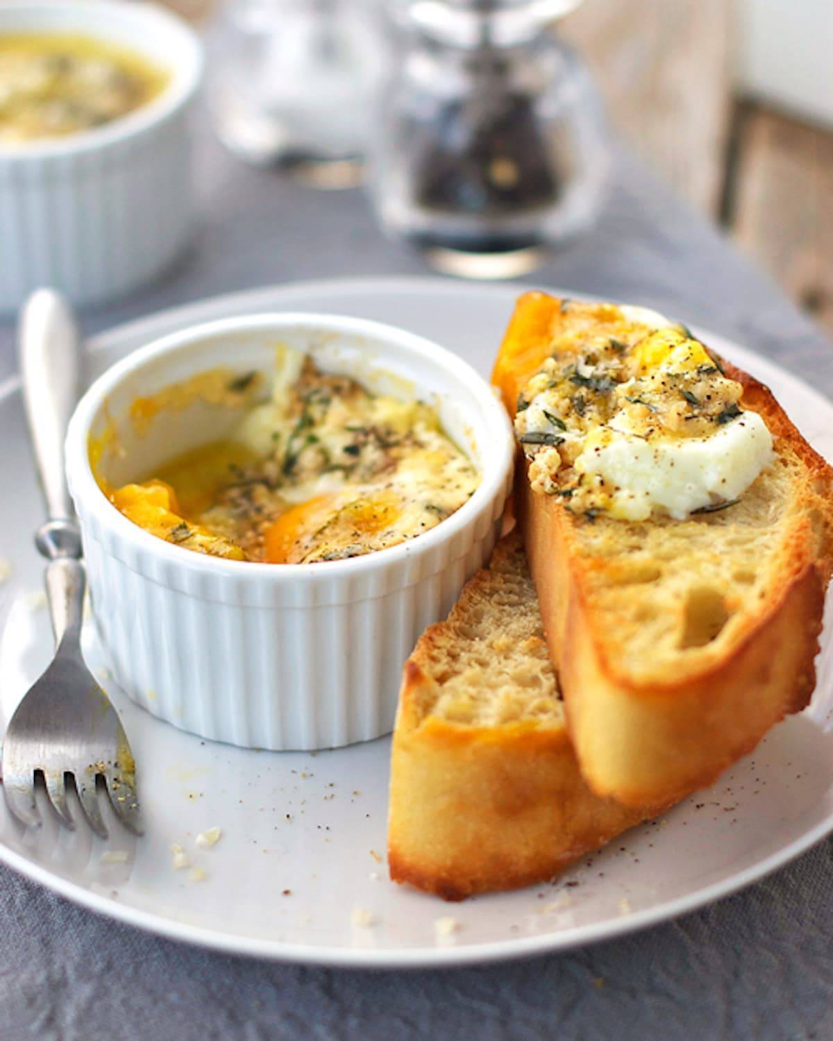 Parmesan baked eggs in a dish with bread.