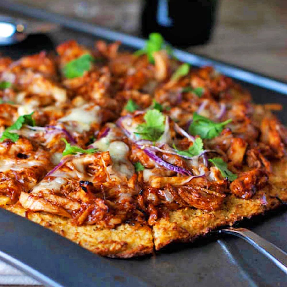 BBQ chicken pizza cut into slices.