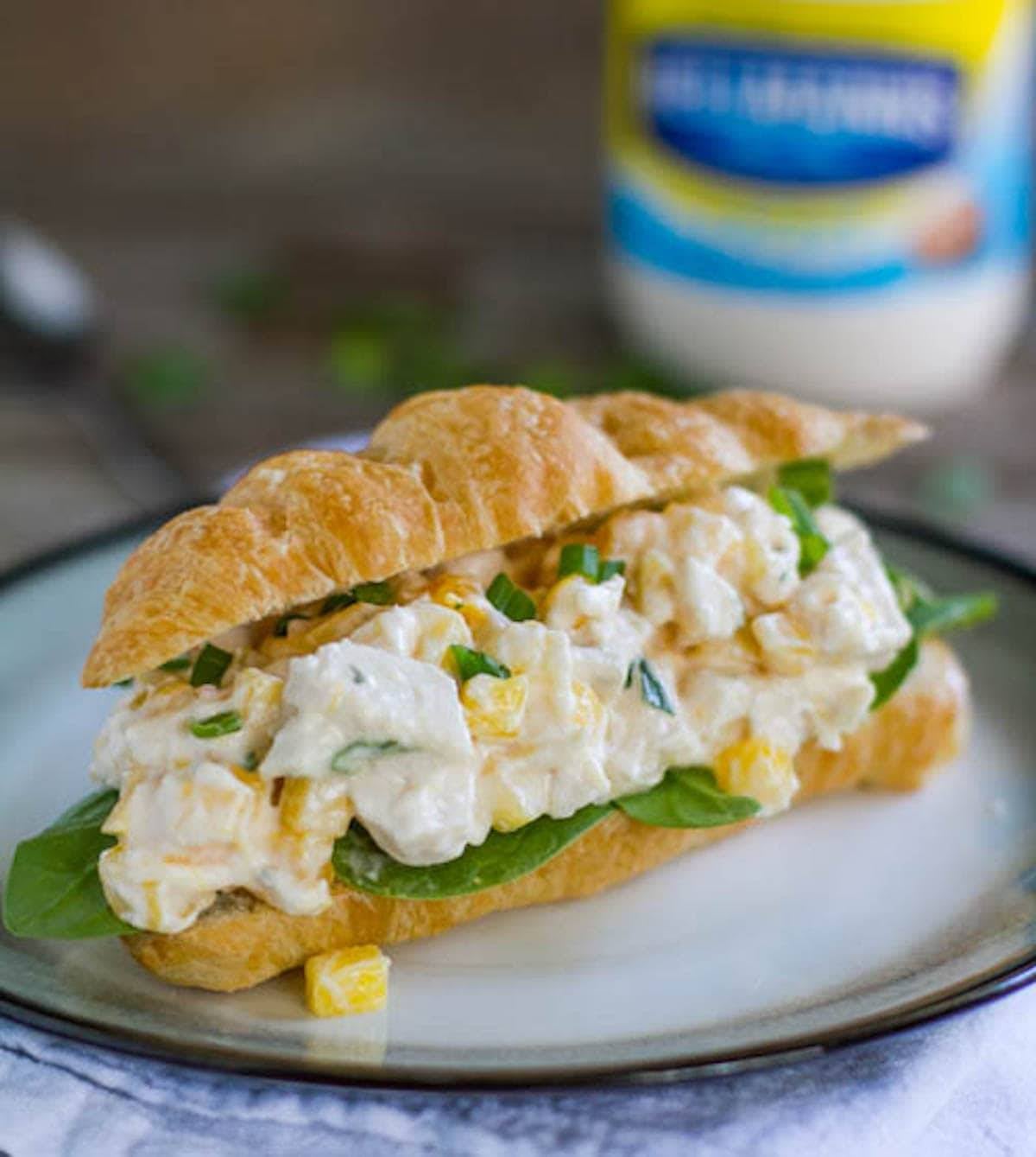 Mango chicken salad sandwich on a plate.